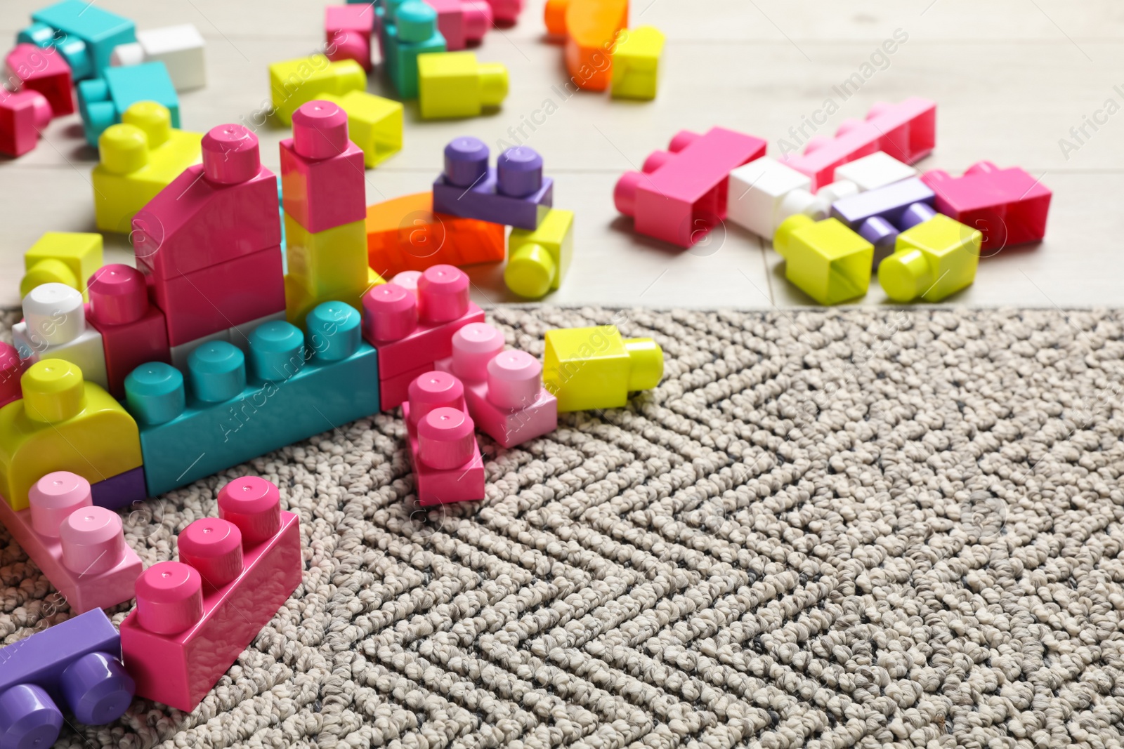 Photo of Colorful plastic building blocks on floor, space for text