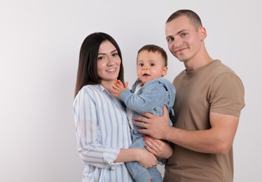 Photo of Portrait of happy family with little child on light background