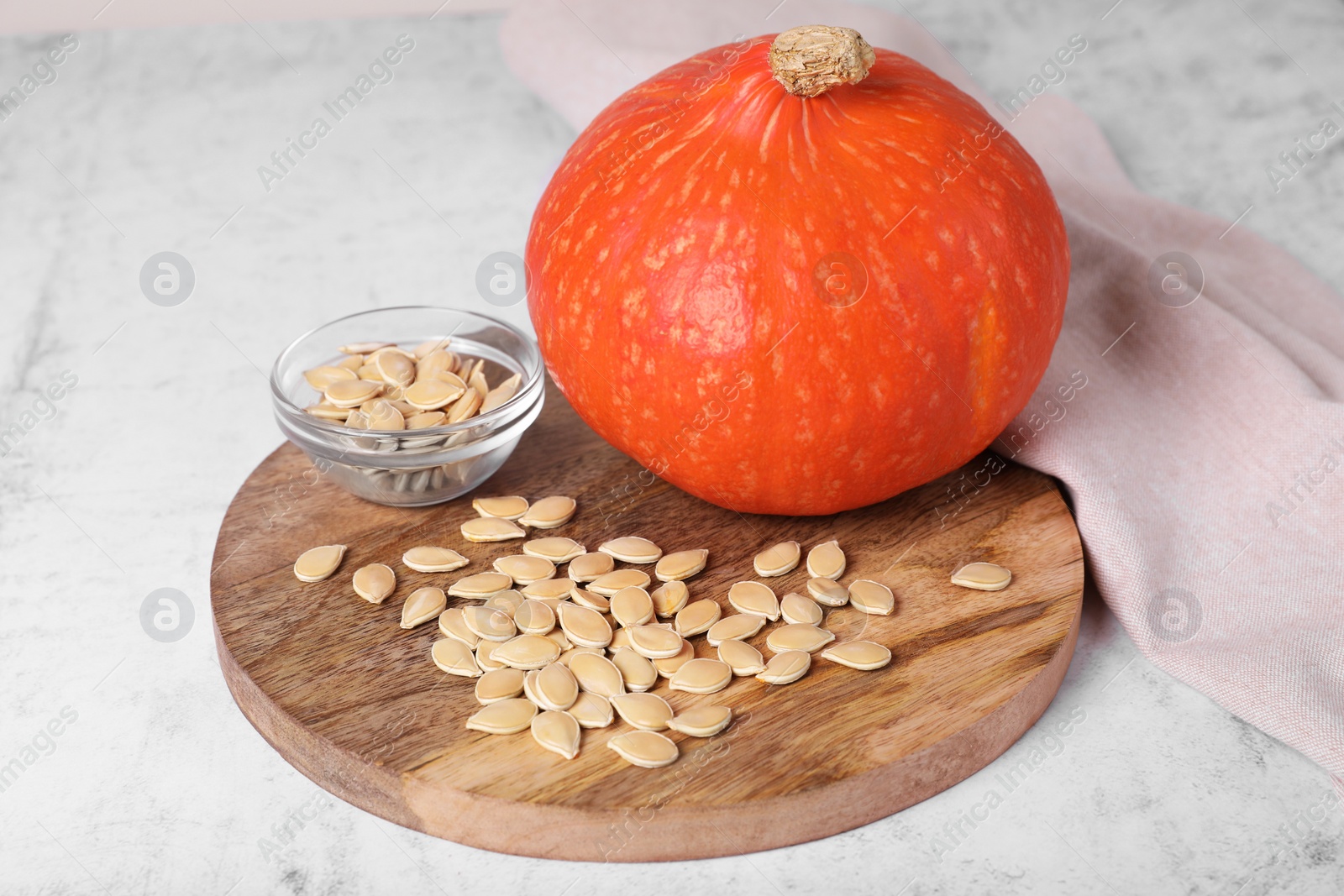 Photo of Fresh pumpkin and vegetable seeds on white table