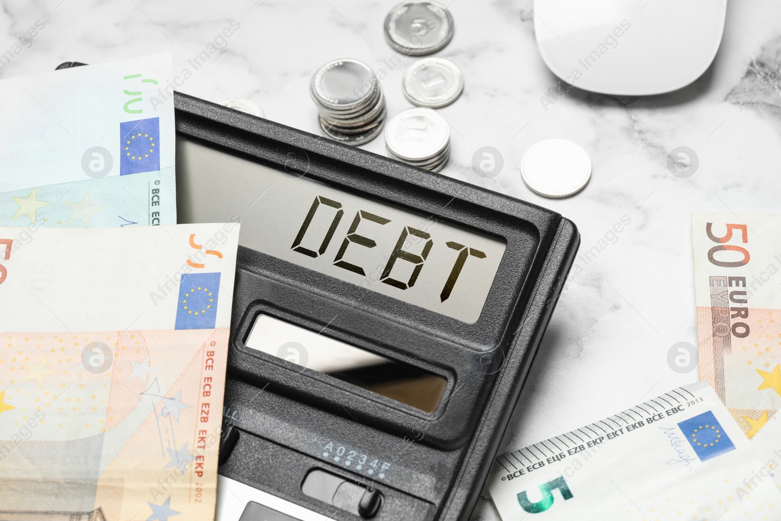 Image of Calculator with word Debt and money on white marble table, closeup