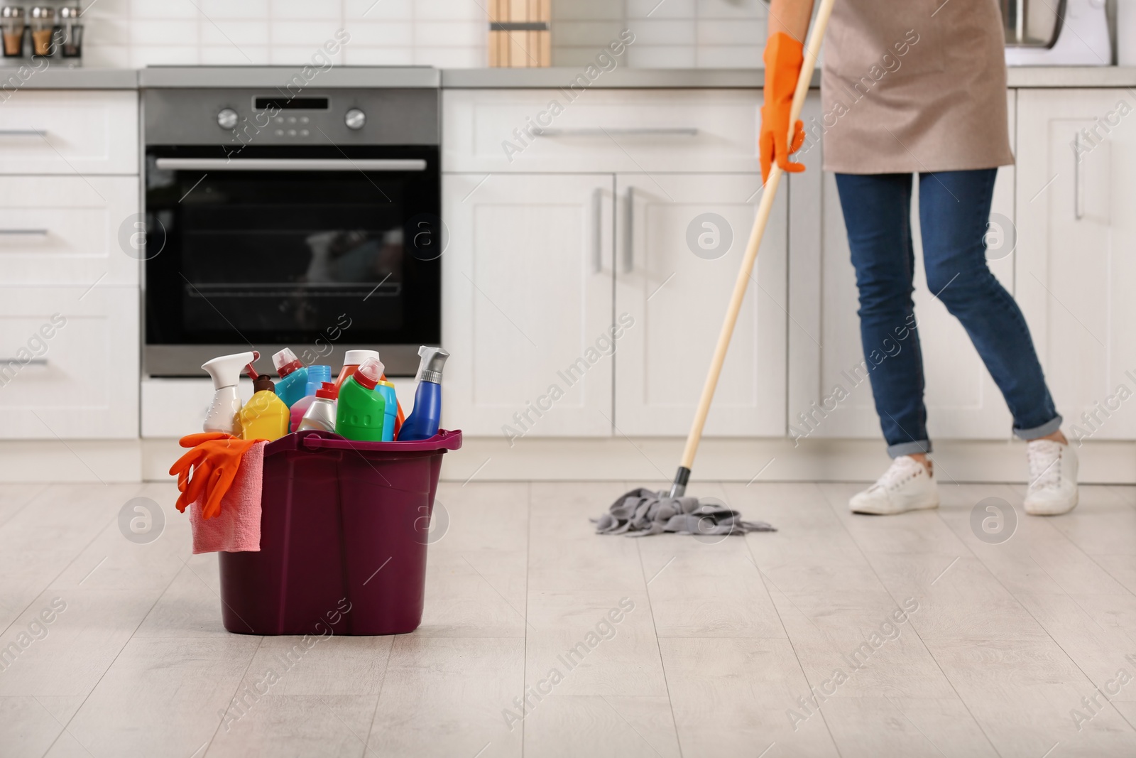 Photo of Set of cleaning supplies on floor in kitchen. Space for text