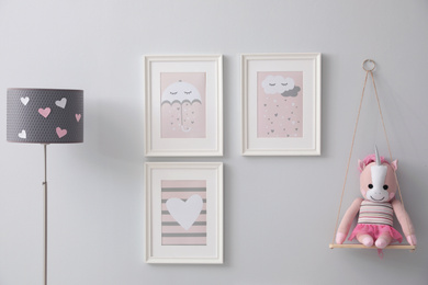 Photo of Kid's toy and beautiful pictures on grey wall
