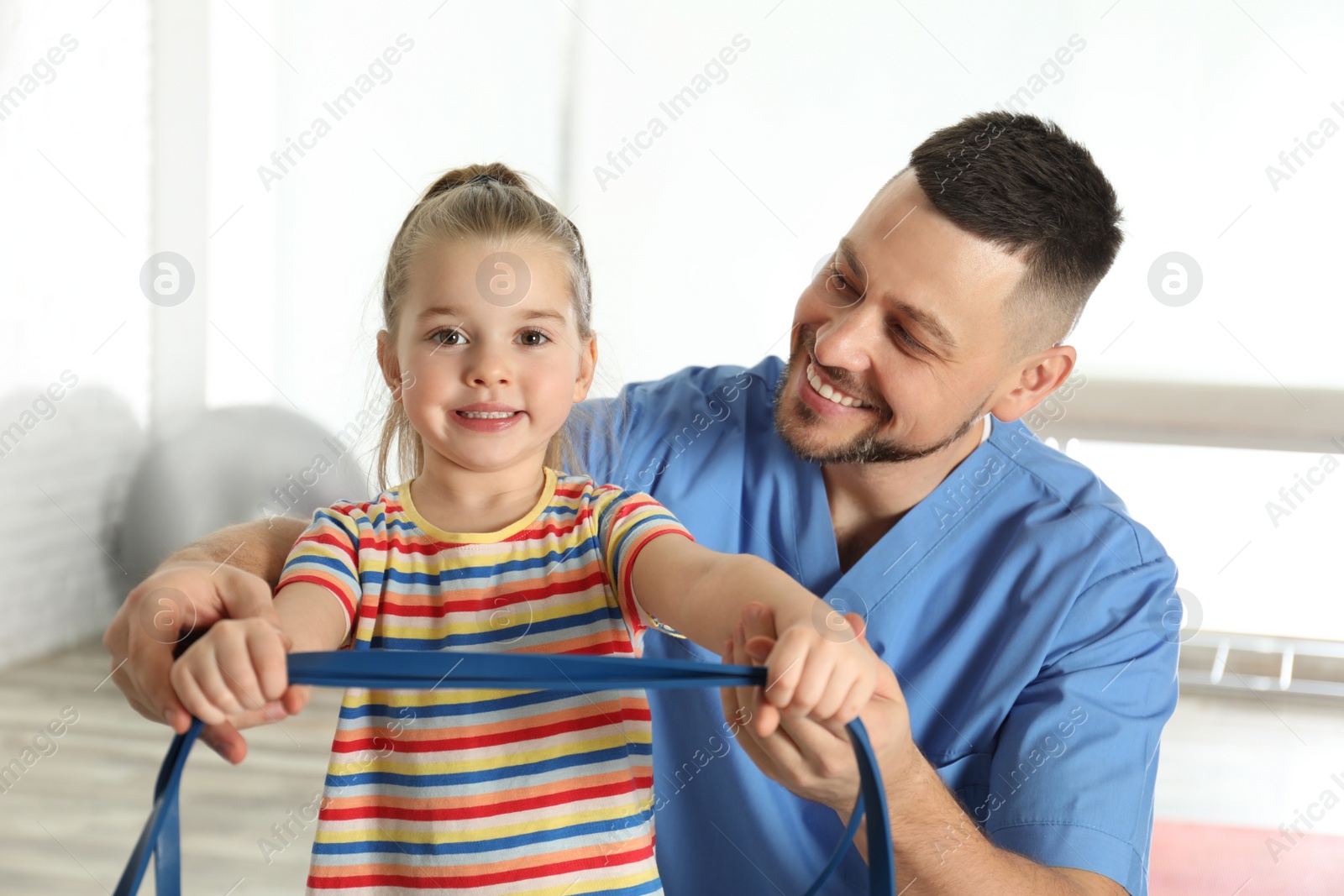 Photo of Orthopedist working with little girl in hospital gym