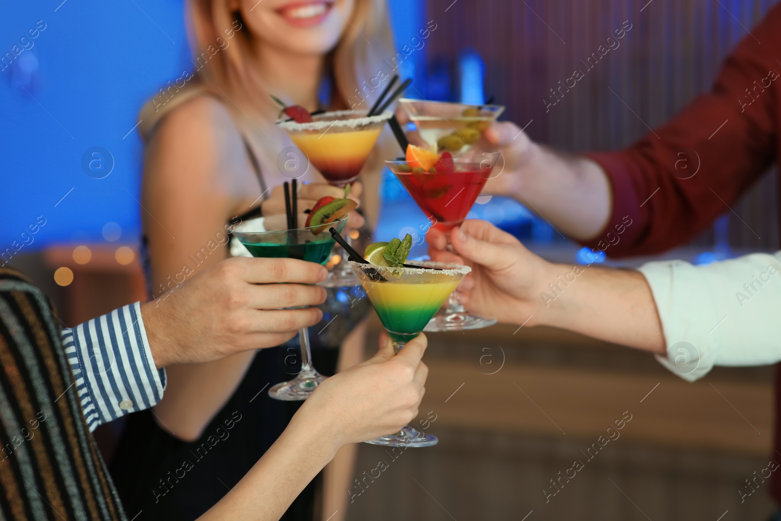 Photo of Group of young people holding martini cocktails at party, closeup