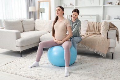 Photo of Doula working with pregnant woman at home. Preparation for child birth