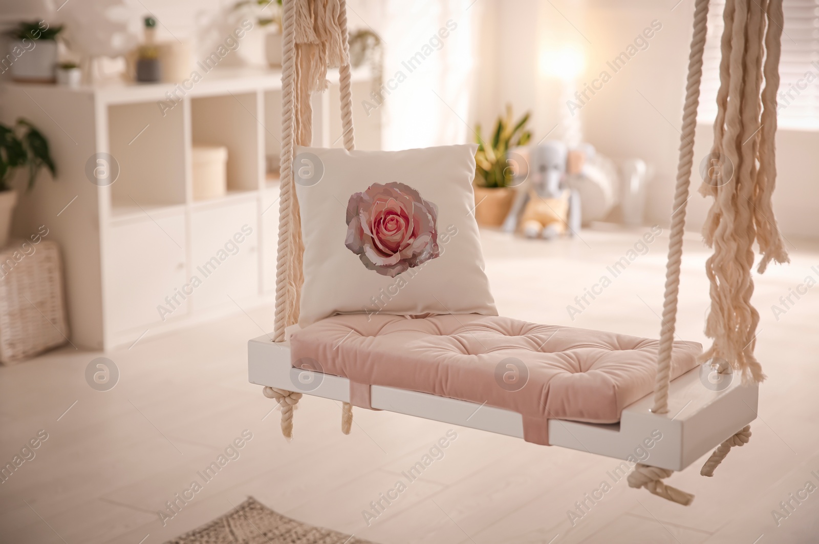 Image of Soft pillow with printed rose on swing indoors