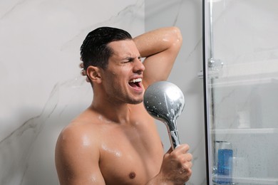 Photo of Handsome man singing while taking shower at home