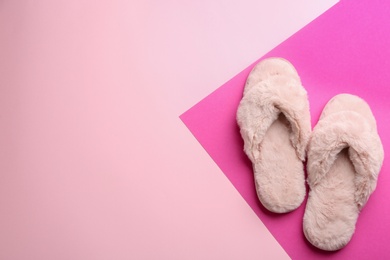 Pair of stylish soft slippers on color background, flat lay. Space for text