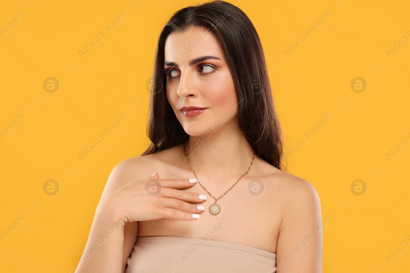 Photo of Beautiful woman with elegant necklace on orange background