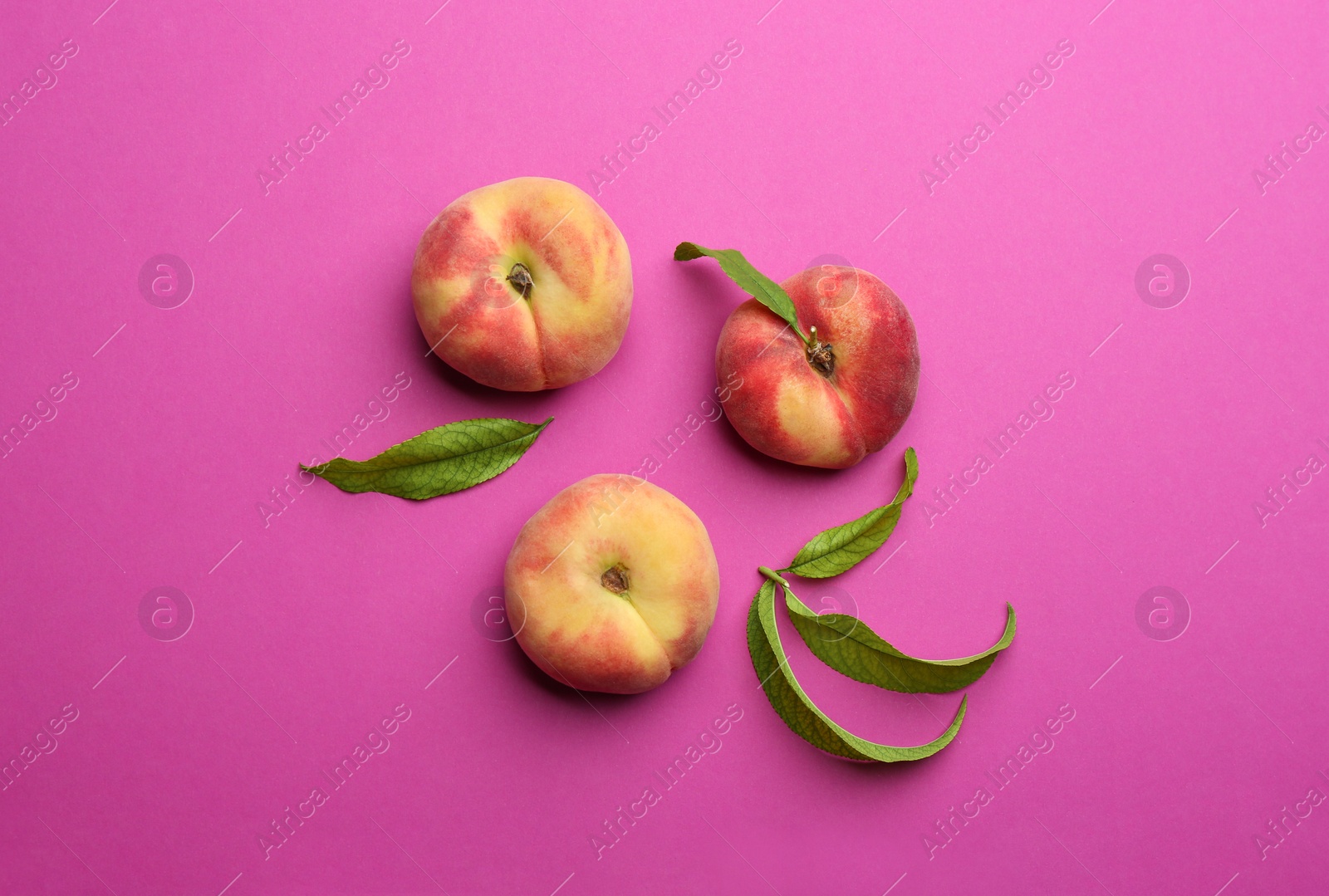 Photo of Fresh donut peaches on pink background, flat lay