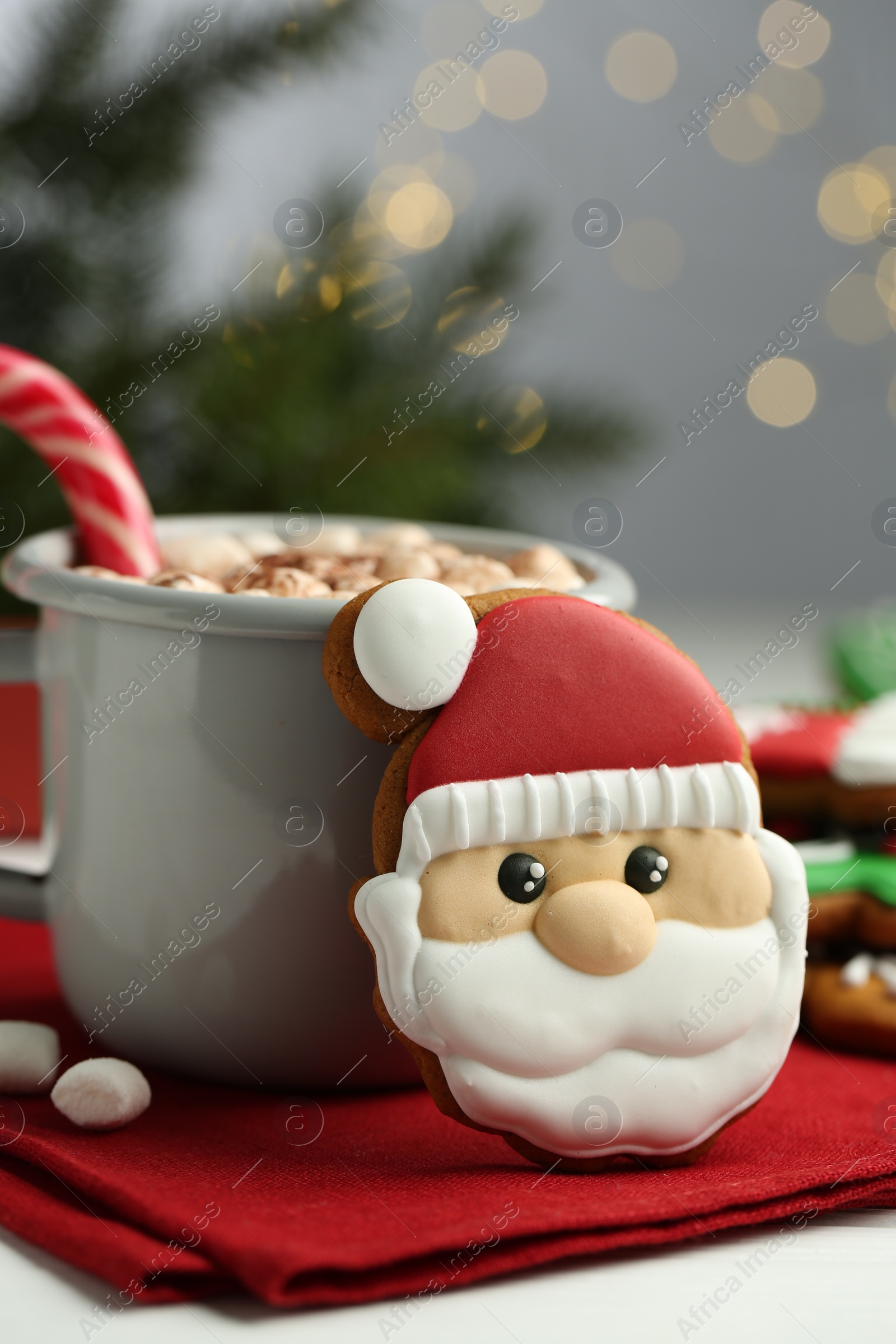 Photo of Tasty homemade Christmas cookie and hot chocolate with marshmallows on white table, closeup