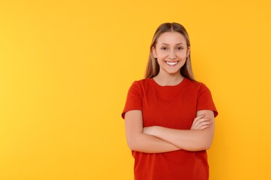 Portrait of beautiful teenage girl on orange background. Space for text