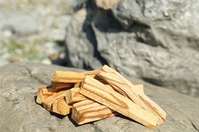 Many palo santo sticks on stone surface, closeup