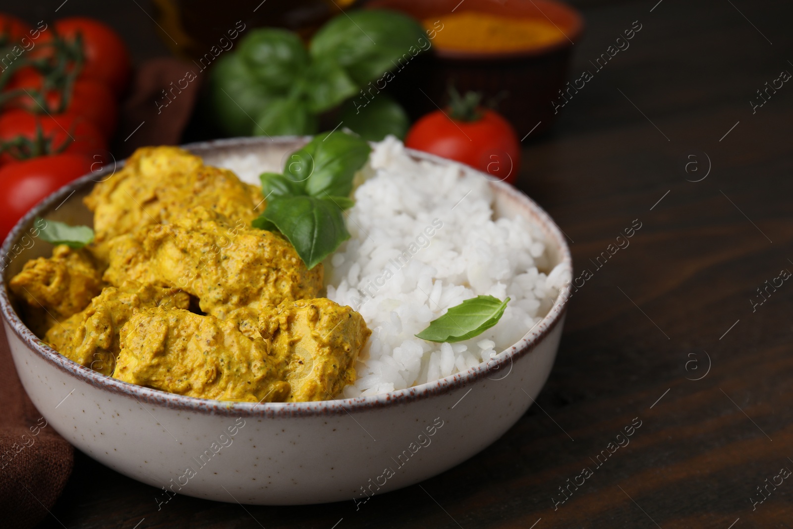 Photo of Delicious rice and chicken with curry sauce on wooden table, closeup