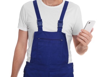 Professional repairman in uniform with phone on white background, closeup