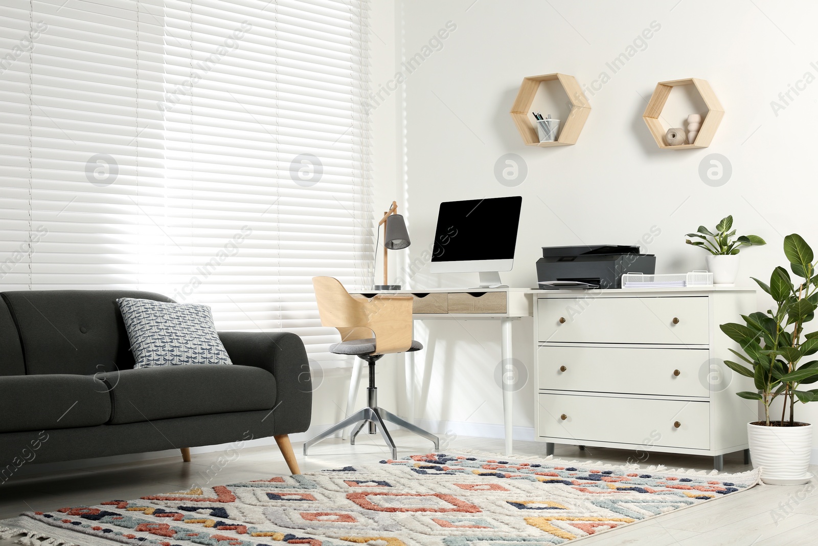 Photo of Stylish workplace with modern computer, printer and lamp