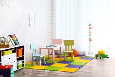 Stylish playroom interior with toys and modern furniture