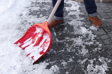 Photo of Man shoveling snow on city street, closeup