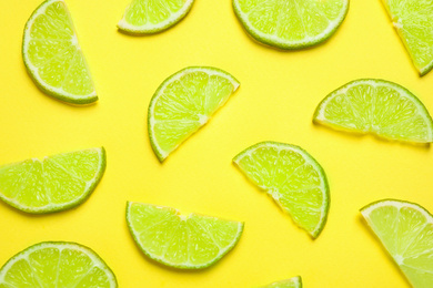 Photo of Juicy fresh lime slices on yellow background, flat lay