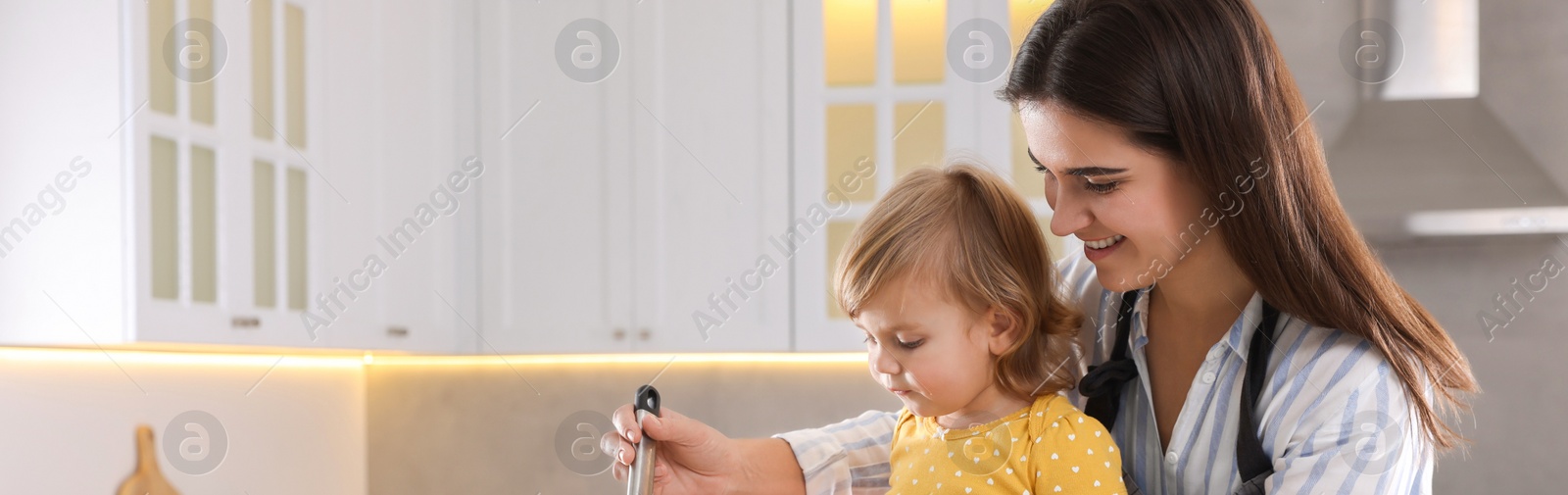 Image of Mother and her little daughter cooking together in kitchen, space for text. Banner design