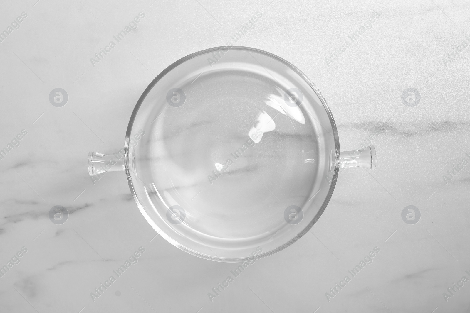 Photo of One empty glass pot on white marble table, top view