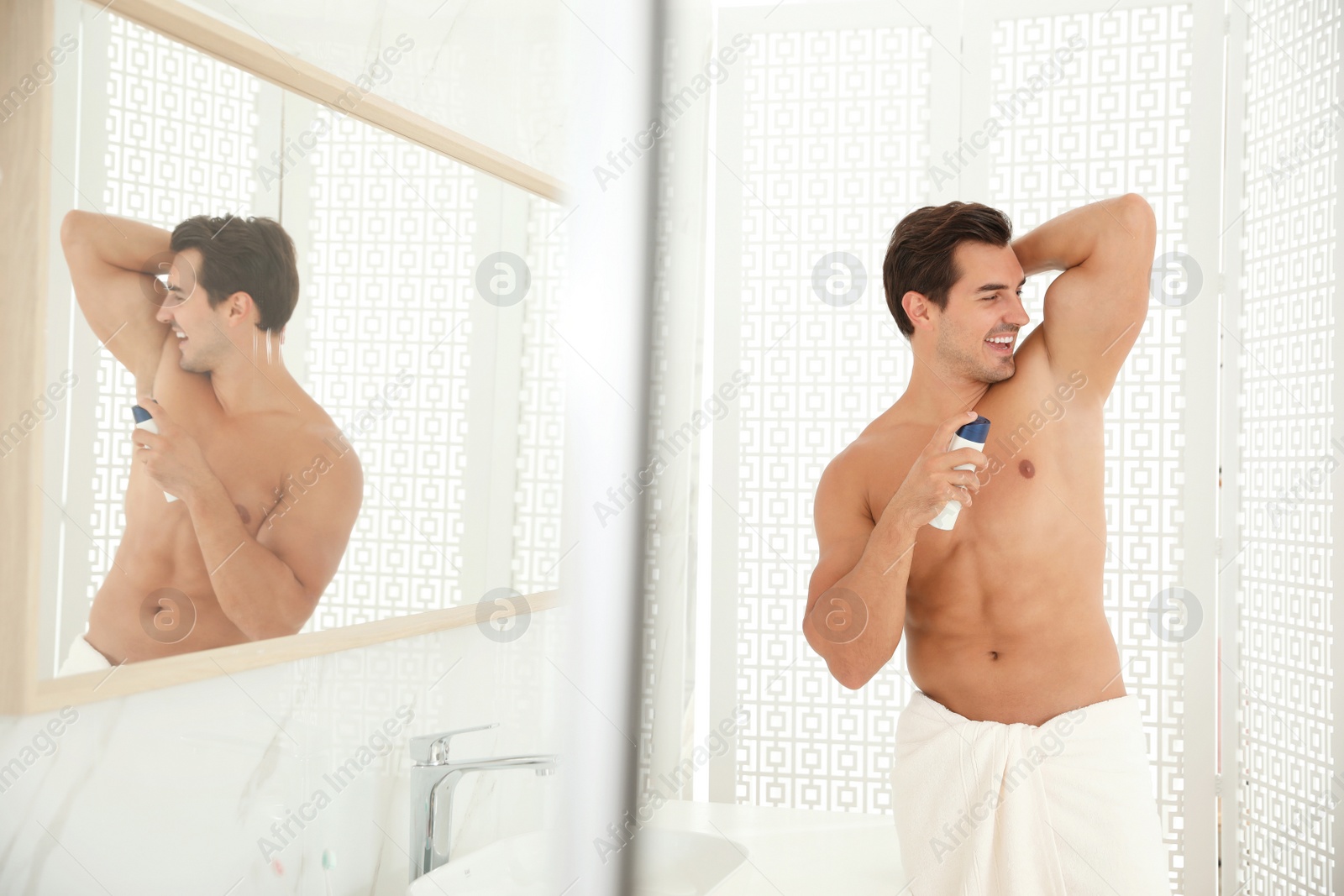 Photo of Handsome young man applying deodorant in bathroom