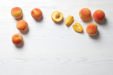 Fresh sweet peaches on wooden table, top view