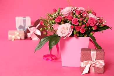 Composition with beautiful bouquet and gift boxes on color background