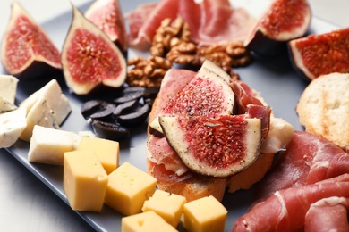 Sandwich with ripe fig and delicious products on grey plate, closeup