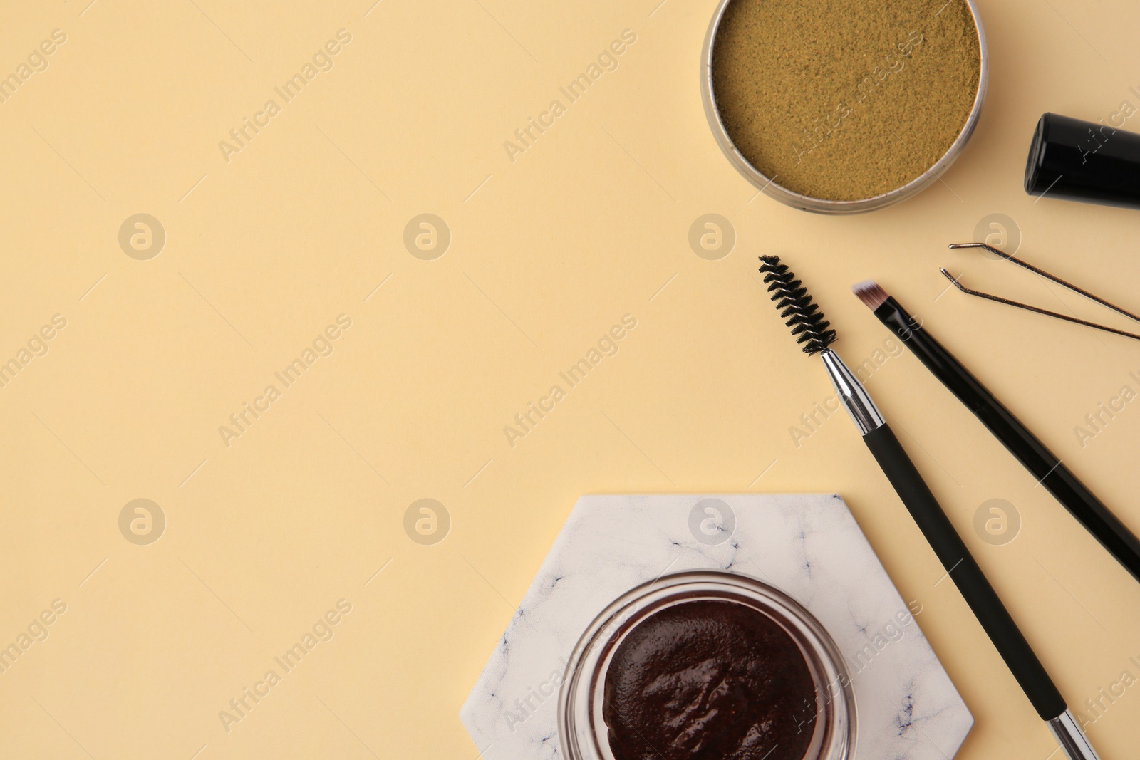 Photo of Flat lay composition with eyebrow henna and tools on beige background. Space for text