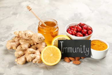 Photo of Card with word Immunity and fresh products on light marble background