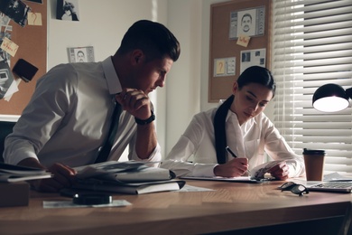 Professional detectives working at desk in office