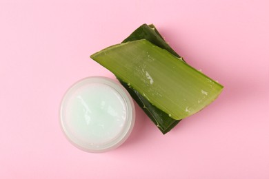 Jar of natural gel and cut aloe on pink background, top view