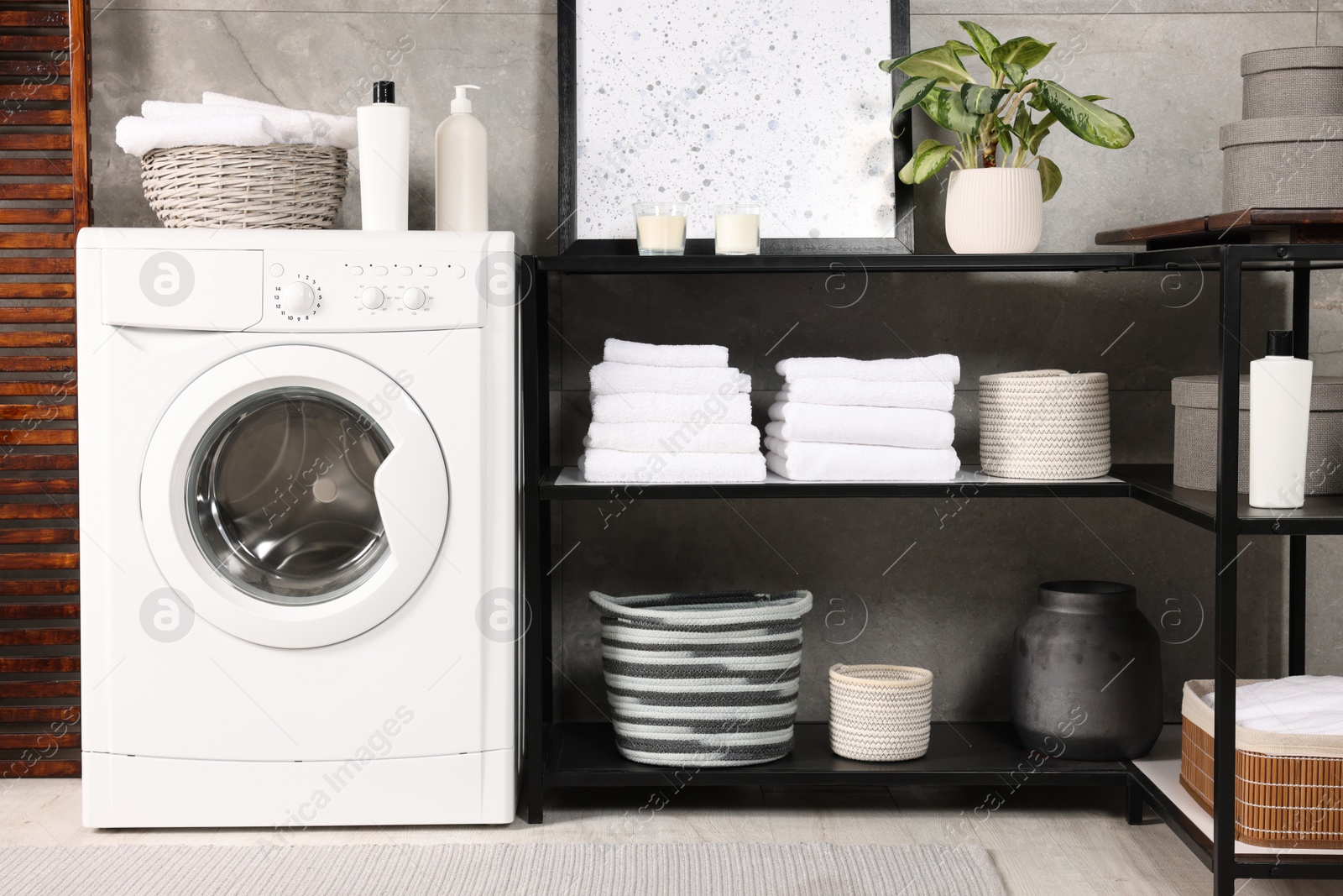 Photo of Stylish laundry room with modern washing machine. Interior design