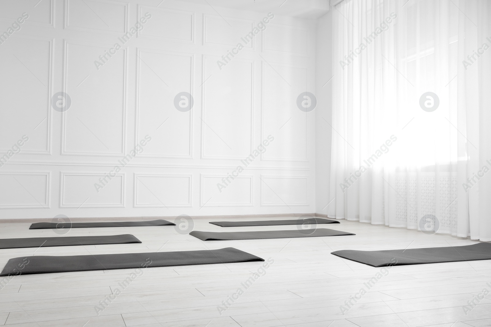 Photo of Spacious yoga studio with exercise mats. Space for text