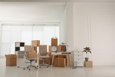 Photo of Cardboard boxes and packed stuff in office. Moving day