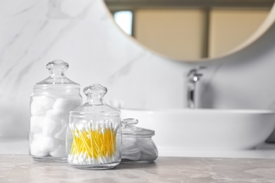 Cotton balls, swabs and pads on light grey marble table in bathroom