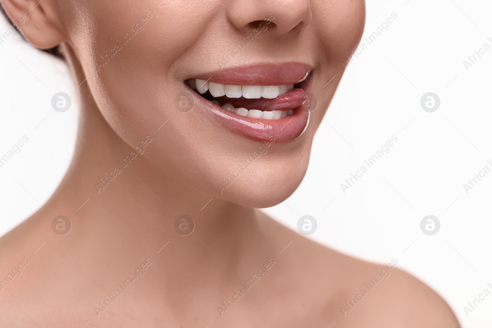 Photo of Woman with beautiful lips licking her teeth on white background, closeup