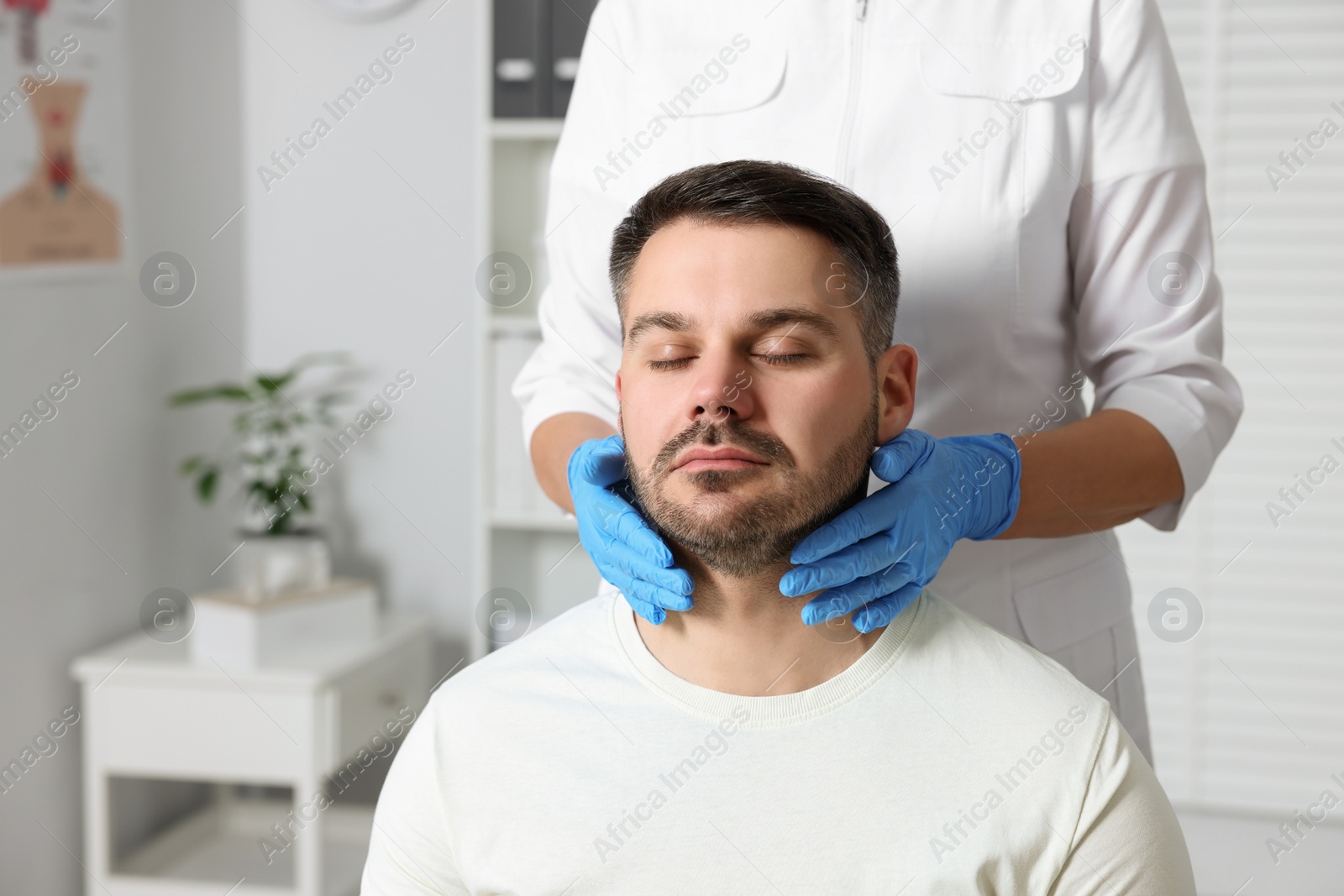 Photo of Endocrinologist examining thyroid gland of patient at hospital, closeup