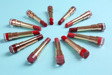 Photo of Composition with different stylish lipsticks on color background