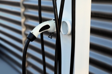 Photo of Electric vehicle charging station outdoors, closeup view