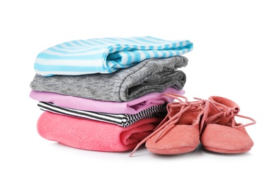 Photo of Children's shoes and stack of clothes on white background