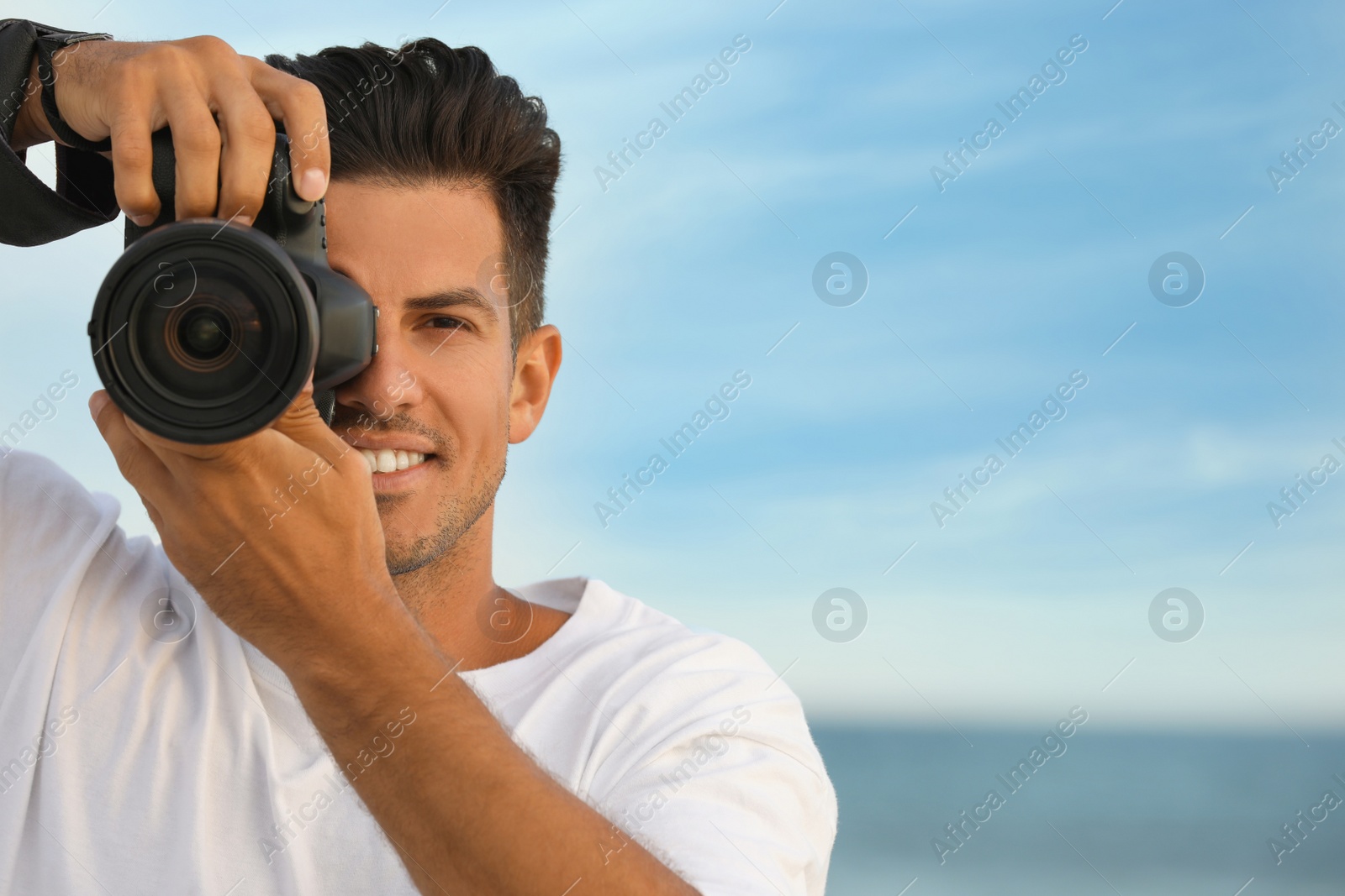 Photo of Photographer taking picture with professional camera near sea