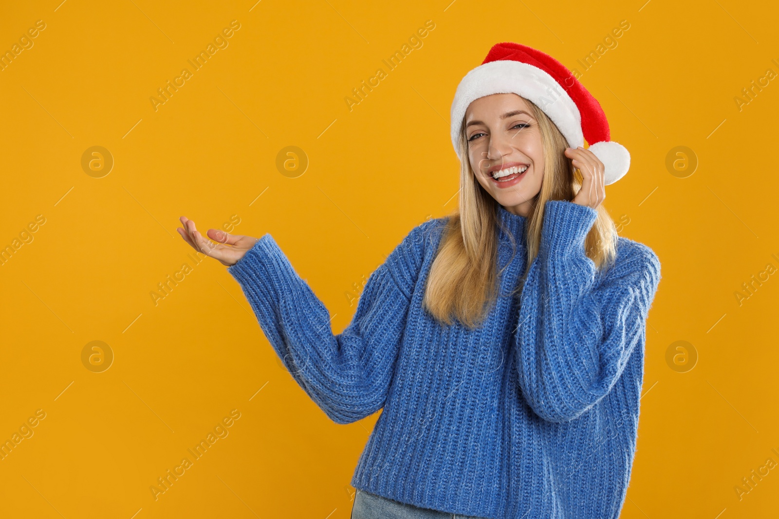 Photo of Happy woman in Santa hat on yellow background, space for text. Christmas countdown