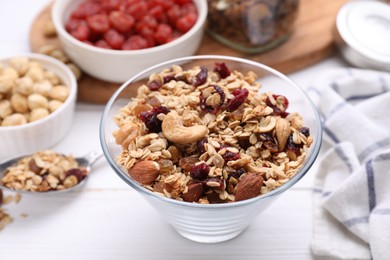 Bowl of tasty granola on white wooden table