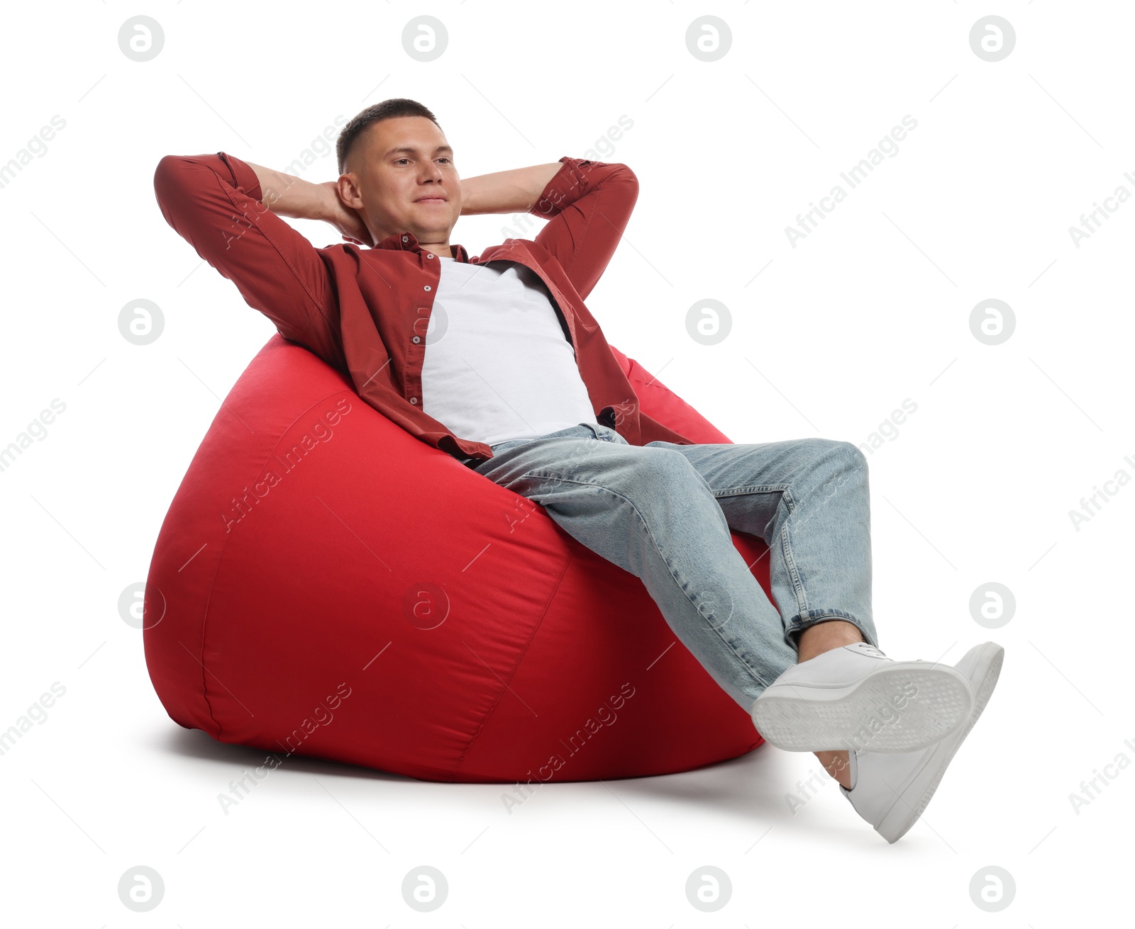 Photo of Handsome man resting on red bean bag chair against white background