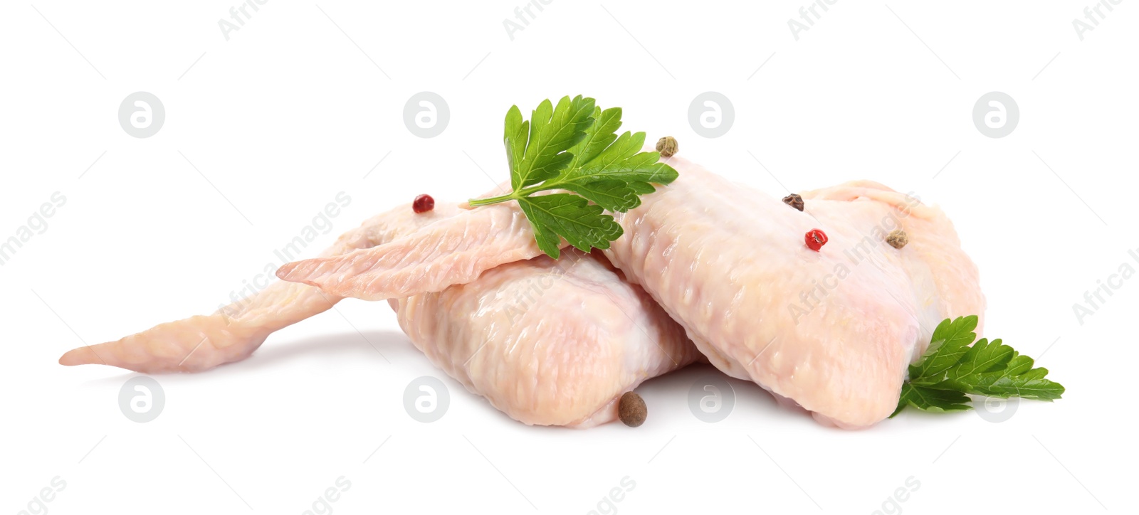 Photo of Raw chicken wings with spices and parsley on white background