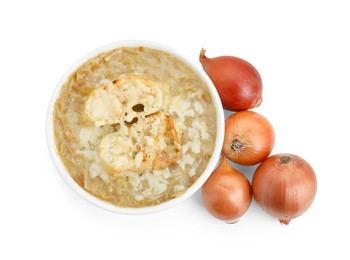 Delicious onion soup with croutons in bowl and onions isolated on white, top view