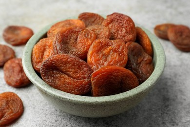 Bowl of tasty apricots on grey table, closeup. Dried fruits