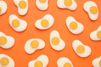 Delicious gummy fried egg candies on orange background, flat lay